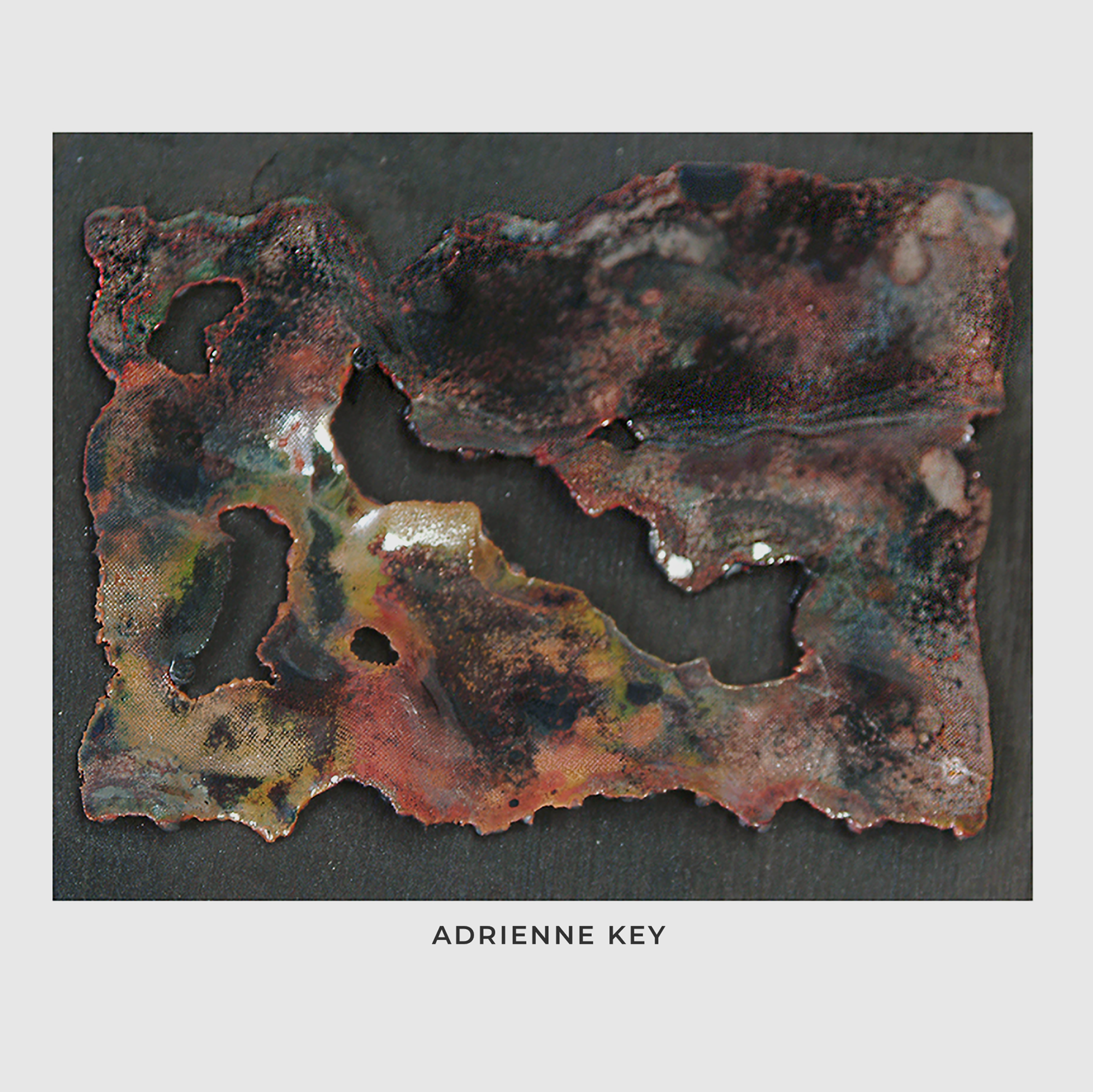 Sculpture of colorful vitreous enamel and glass fused to copper mesh and charred and nailed to a piece of wood