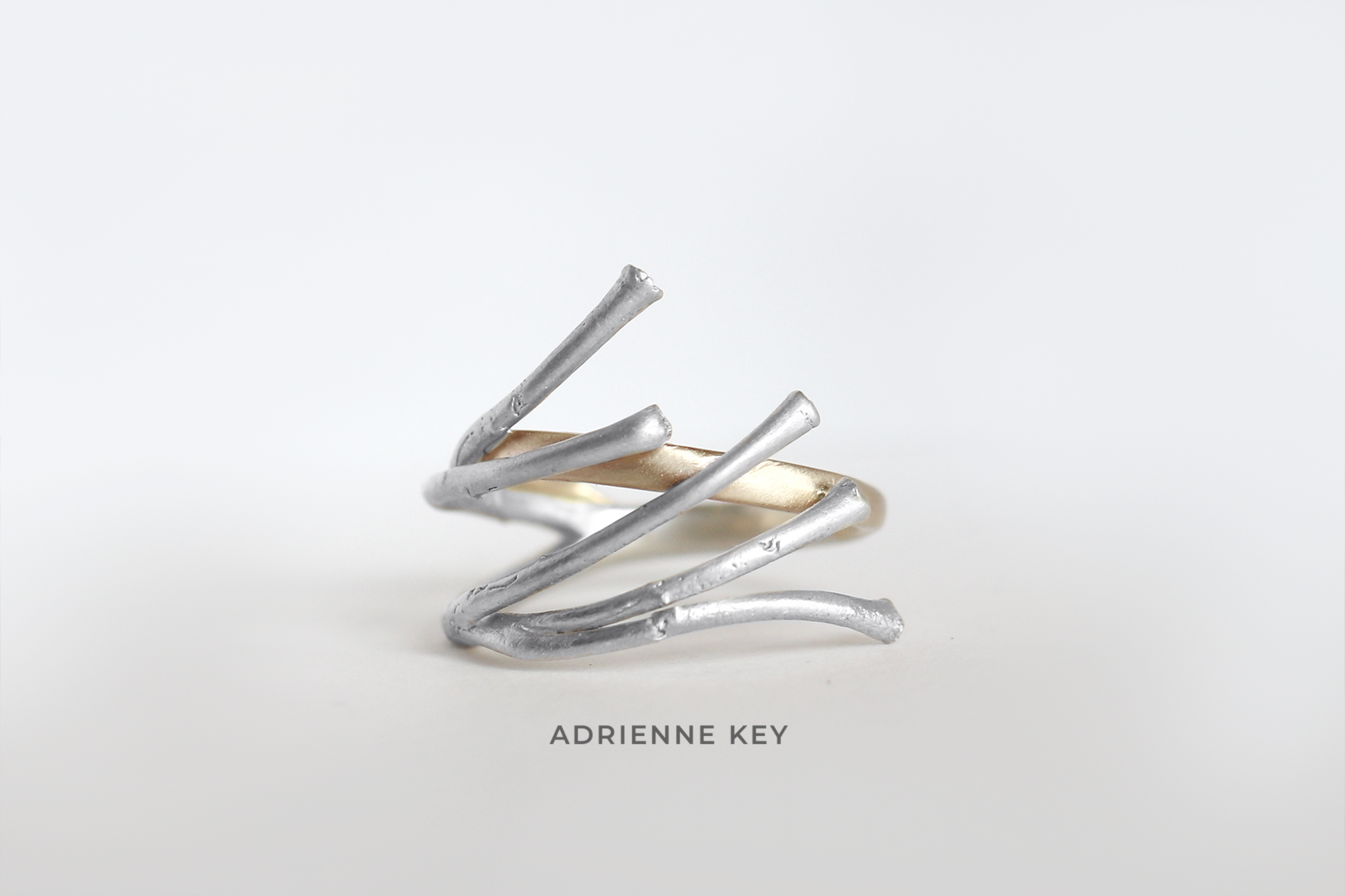 Cast sterling silver branches formed into a ring with 14k yellow gold detailing