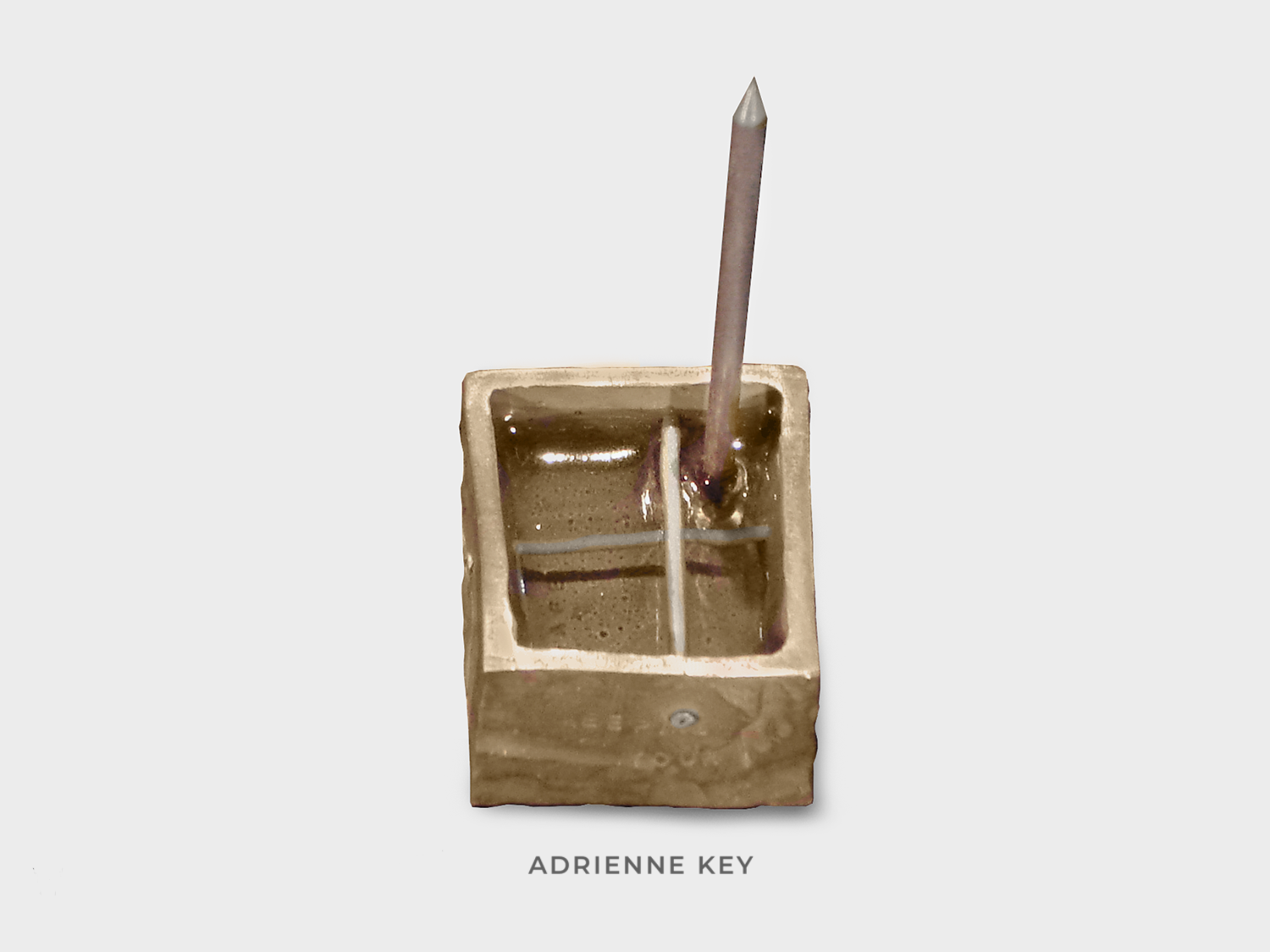 Sculpture of a bronze box with aluminum tubes riveted inside and a sharpened steel nail sticking out of clear resin and the word safe stamped inside