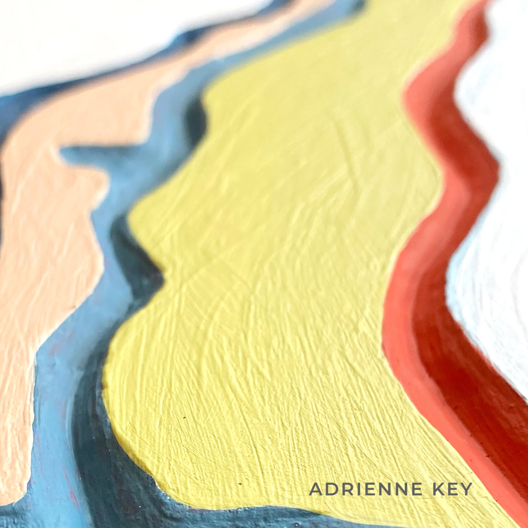 Detail of a hand carved wood artwork with bright painted colors