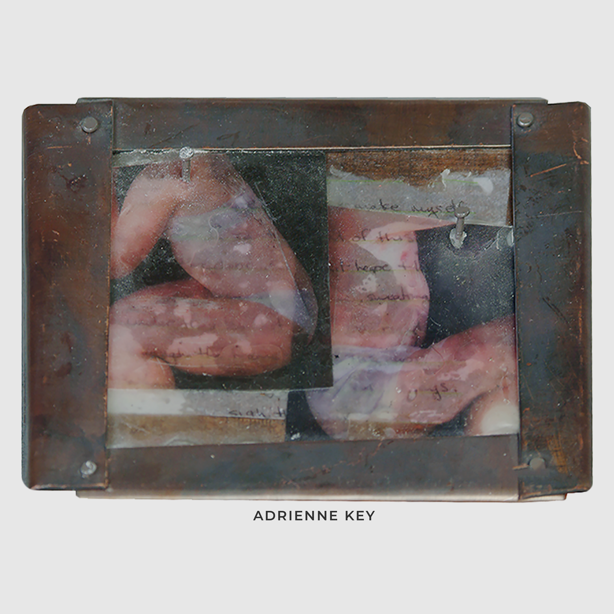 Sculpture on a wood base with rustic copper sheet nailed in as a frame of writing underneath a transparency of two people back to back
